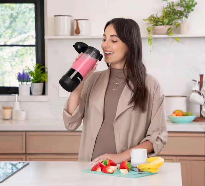 Nutribullet Portable Erfahrung Frau trinkt Smoothie in der Küche